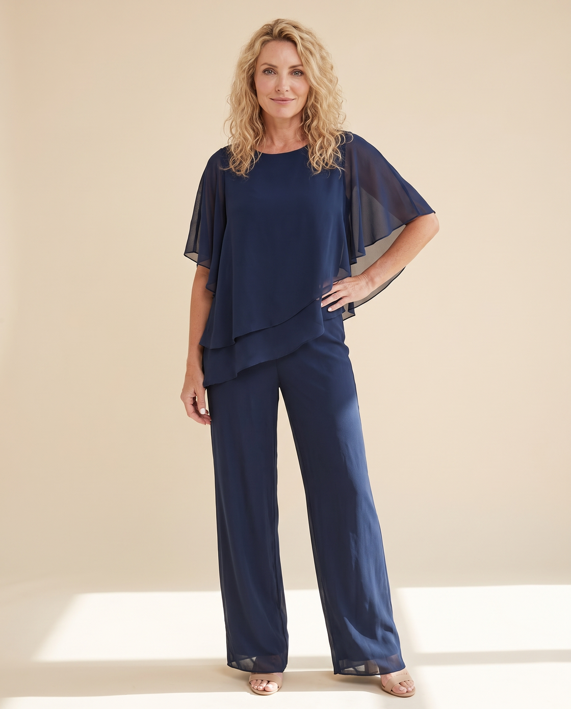 A woman wearing the June & Louise Elara Set, the double-layer asymmetrical top falling in a long line over wide-leg palazzo pants.