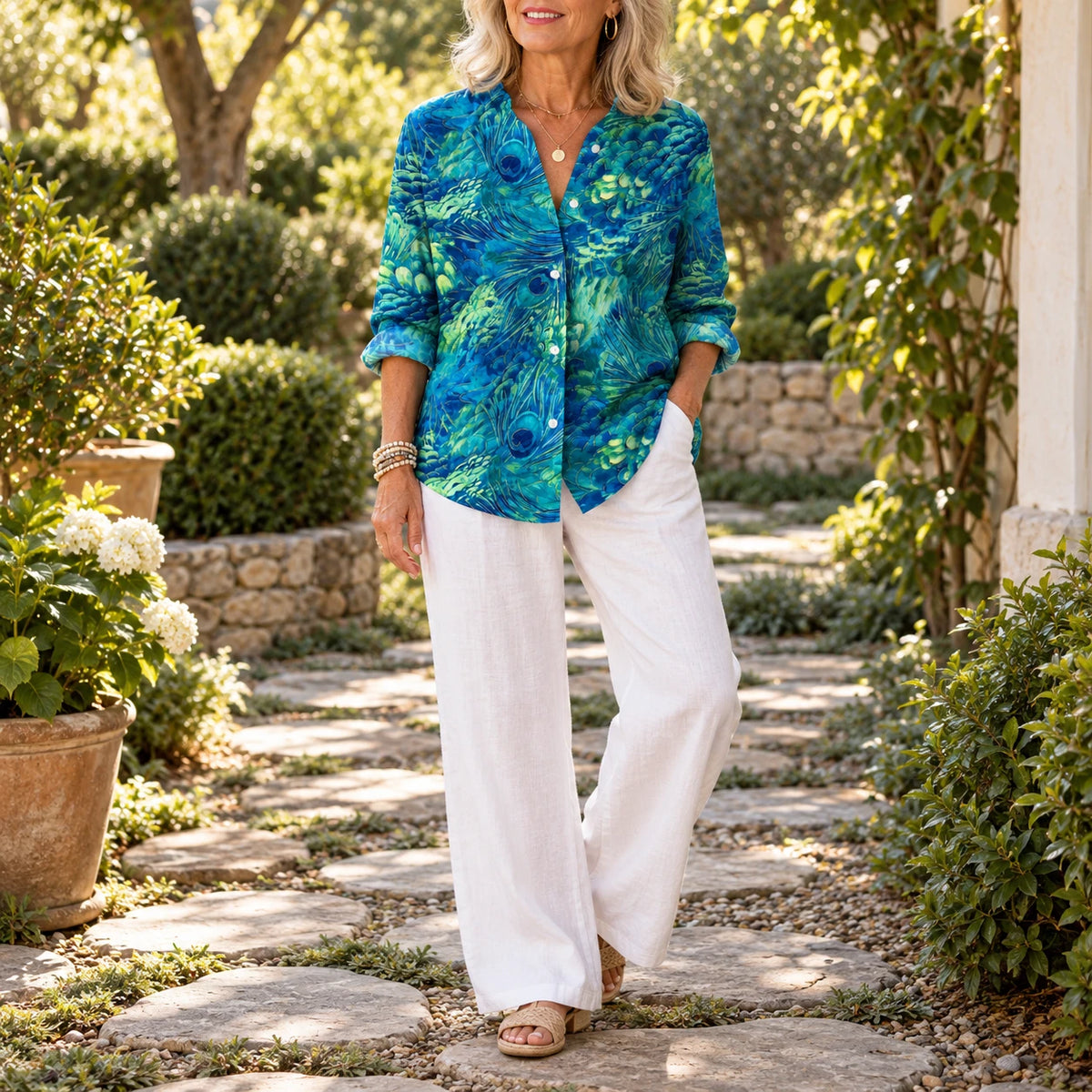 Florina Grace Blouse worn untucked over white pants, full length in the garden