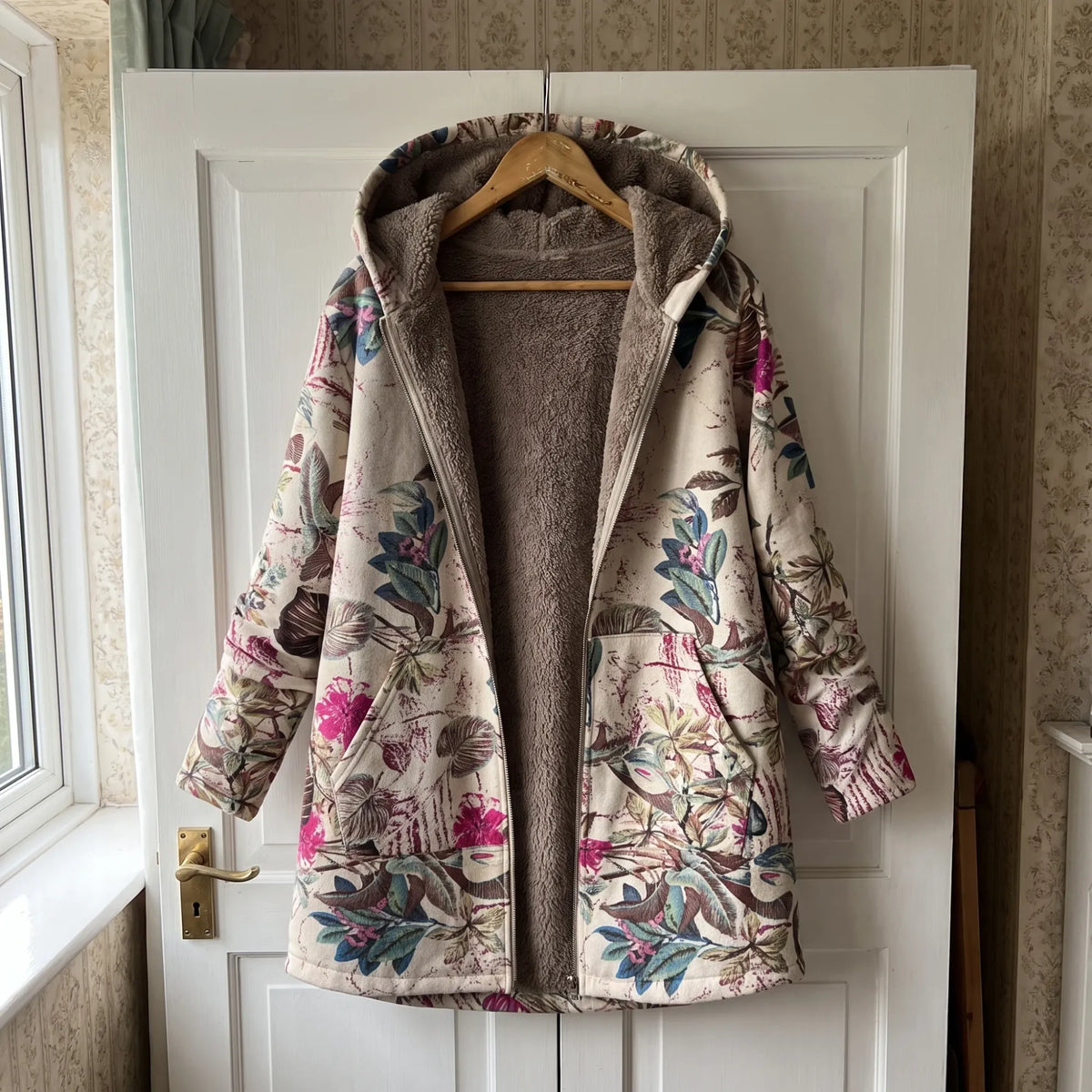 The Melvaris jacket on a hanger on the door, open to show the fleece lining and hood
